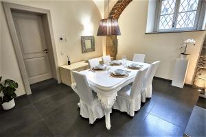 a dining room with a white table and white chairs at ASTRA-Modern Loft Cathedral View in Bergamo