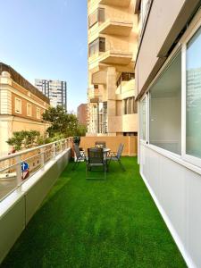 - un balcon avec de l'herbe verte sur le côté du bâtiment dans l'établissement Malagueta beach II & Private Terrace by ELE Apartments, à Malaga