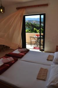 two beds in a room with a view of a patio at House Margot in Palekastron