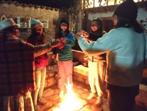 a group of people standing around a fire at Casa vivencial Mamá Vivi in Coporaque