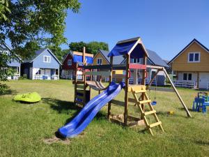 a playground with a slide in a yard with houses at OSADA NA WYSPIE in Gdańsk