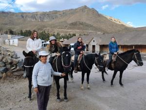 a group of people riding horses in the desert at Casa vivencial Mamá Vivi in Coporaque