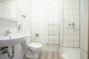 a bathroom with a toilet and a sink and a shower at Hotel Bergheim in Bergheim