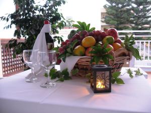 a table with a basket of fruit and a bottle of wine at Despina Studios in Agia Marina Nea Kydonias