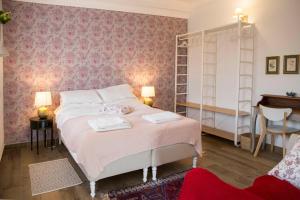 una camera da letto con un letto con carta da parati rosa di Villa del Tempo a Desenzano del Garda