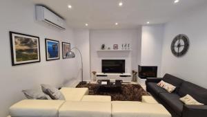a living room with a couch and a tv at The Poolside Bliss in San Ġwann
