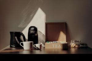 una mesa con tazas de café y una caja de té. en Quarenghi16, en Bérgamo
