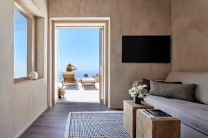 a living room with a couch and a view of the ocean at Santorini Sky, The Retreat in Pyrgos