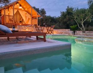 a luxury house with a swimming pool and a tent at AURAS - Glamping Eco Resort in Biograd na Moru