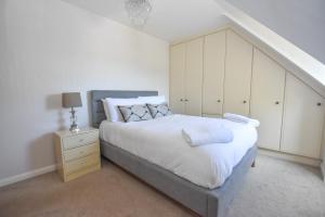 a bedroom with a large bed and a staircase at Birchwood in Skegness in Skegness
