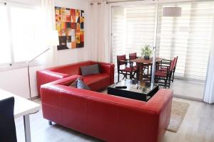 a living room with a red couch and a table at Appartement Rosa N&B met Groot Terras met Zeezicht -70m van Strand in Calpe