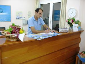 a man is sitting at a counter in a room at Despina Studios in Agia Marina Nea Kydonias +20 photos