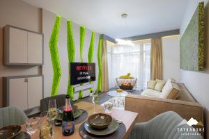 un salon avec une table et un canapé dans l'établissement Luxusný Apartmán Hrebienok Resort - Tatranské Apartmány, à Starý Smokovec