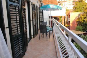 een balkon met een tafel en een parasol bij Apartments Iris in Herceg-Novi
