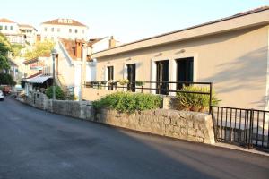 een gebouw op een straat met een hek en planten bij Apartments Iris in Herceg-Novi +28 foto's