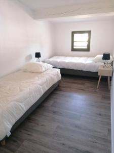 2 camas en una habitación con suelo de madera en Maison cosy Bassin d'arcachon, en Arès
