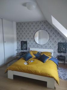 1 dormitorio con cama amarilla y espejo en Chez Driss, en Crévin