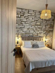 a bedroom with a bed with a stone wall at Peri Elxis Luxury Suites in Mouresi