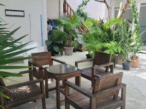 eine Terrasse mit einem Tisch, Stühlen und Pflanzen in der Unterkunft Palm Residence in Rasdu