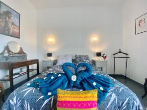 1 dormitorio con 1 cama con manta azul en Guest-house de l’amandier - Vue cité médiévale, en Roullens