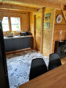 una cucina con tavolo e sedie in una stanza di Rajskie Pluski Slow Life nad jeziorem a Pluski