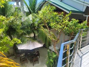 einen Blick über eine Terrasse mit Tischen und Bäumen in der Unterkunft Palm Residence in Rasdu