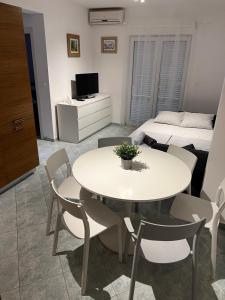 salon ze stołem, krzesłami i łóżkiem w obiekcie Apartman LOTA w Novalji