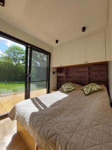 Un dormitorio con una cama grande y una ventana grande. en Ekolandia, en Orneta