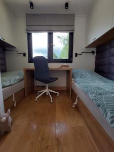 een slaapkamer met een bureau en een stoel naast een bed bij Ekolandia in Orneta