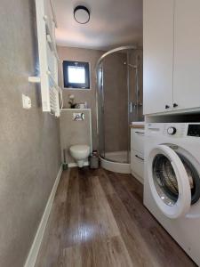 a bathroom with a washing machine and a toilet at Ekolandia in Orneta