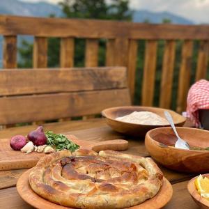 einen Holztisch mit Schalen mit Lebensmitteln auf einem Tisch in der Unterkunft Koliba Kod Begija in Paljevine