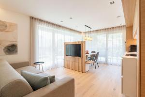 a living room with a couch and a tv at VANEA - Alp Relax Guesthouse in Chienes