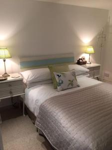 a bedroom with a bed with two night stands and two lamps at Stone Cottage in Thornage