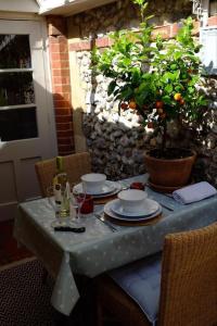 a table with plates and glasses and a plant on it at Stone Cottage in Thornage