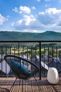 une chaise sur un balcon avec vue sur les montagnes dans l'établissement Słoneczny apartament z widokiem na góry, à Szklarska Poręba