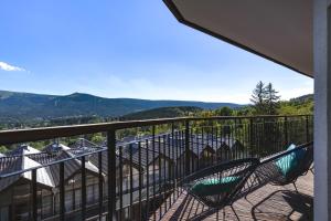 un balcon avec des chaises et une vue sur les montagnes dans l'établissement Słoneczny apartament z widokiem na góry, à Szklarska Poręba
