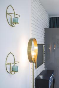 La salle de bains est pourvue de 2 lumières sur le mur et d'un lavabo. dans l'établissement Słoneczny apartament z widokiem na góry, à Szklarska Poręba 5 autres photos