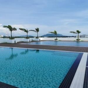 a large swimming pool with palm trees in the background at Preferred30 3R2B 7pax Meritus Perai in Perai
