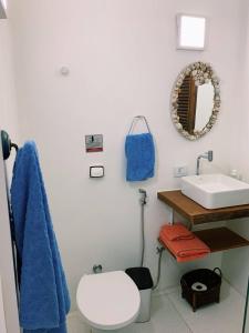 Un baño con lavabo, inodoro y espejo. en Loft Queen Apartamento Charmoso no Centro Histórico de Ilhabela, en Ilhabela