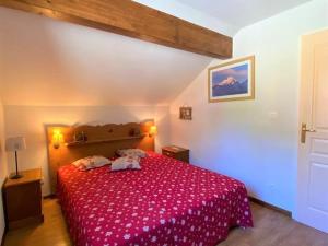 une chambre avec un lit avec un couvre-lit rouge dans l'établissement Chalet Mitoyen 3 Pièces avec Local Ski et Parking Gratuit - FR-1-504-3, à Saint-Étienne-en-Dévoluy 13 autres photos