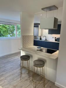 a kitchen with two bar stools and a counter at Strada Apartment in Edinburgh