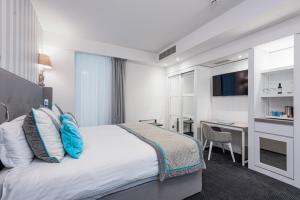 a hotel room with a bed and a desk at Hotel Juliani - Boutique Hotel in St. Julianʼs