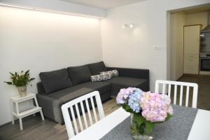 a living room with a couch and a table with flowers at Apartma pri lipi in Bohinj
