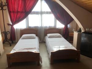 deux lits dans une chambre avec une grande fenêtre dans l'établissement VILLA PEPETO Durres Albania, à Durrës