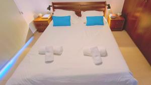 ein Bett mit weißen Handtüchern und blauen Kissen darauf in der Unterkunft STAY Panorama - Kamelia Villa in Peyia + 97 Fotos