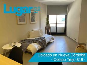 a bedroom with a bed and a table in it at Departamentos Lugar in Cordoba