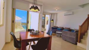 ein Wohnzimmer mit Tisch und Stühlen und einer Couch in der Unterkunft STAY Panorama - Kamelia Villa in Peyia