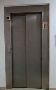 Duas portas de elevador num edifício com um sinal. em City Inn em Lisboa