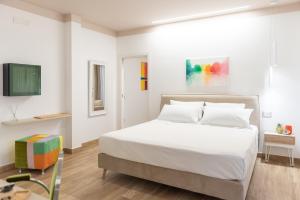 biała sypialnia z łóżkiem i telewizorem w obiekcie Vemaga Luxury Stay in Pompeii w mieście Pompeje