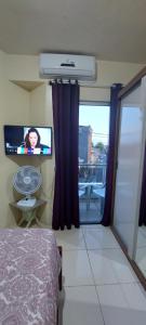 um quarto com uma televisão, uma cama e uma janela em Apart-Norte Flat Belém Aeroporto em Belém